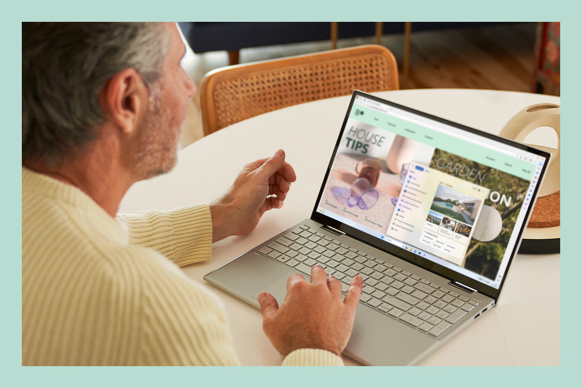 Ein Mann arbeitet mit einem Laptop mit Windows 11.